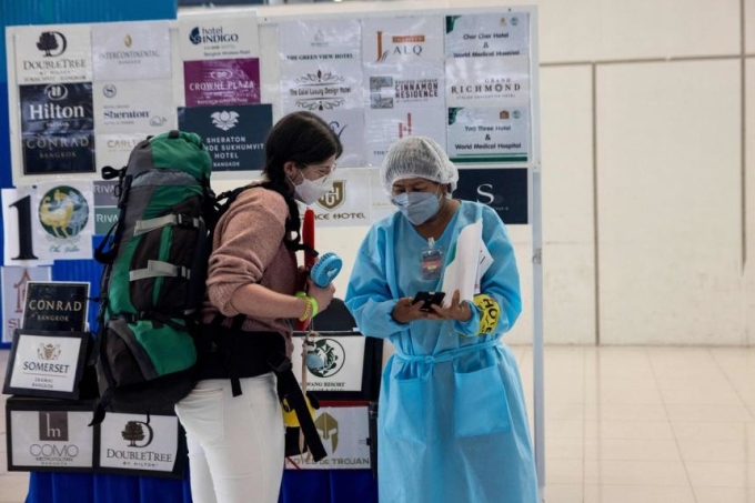 Khách du lịch Thái Lan được nhân viên y tế hướng dẫn quy định phòng dịch, xét nghiệm Covid-19 tại Bangkok hồi tháng 2/2022.