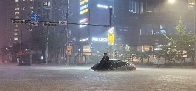 Một người đàn ông bất lực do phương tiện gặp sự cố khi đi trong đoạn ngập nước do mưa lớn ở Seoul tối ngày 8/8/2022.