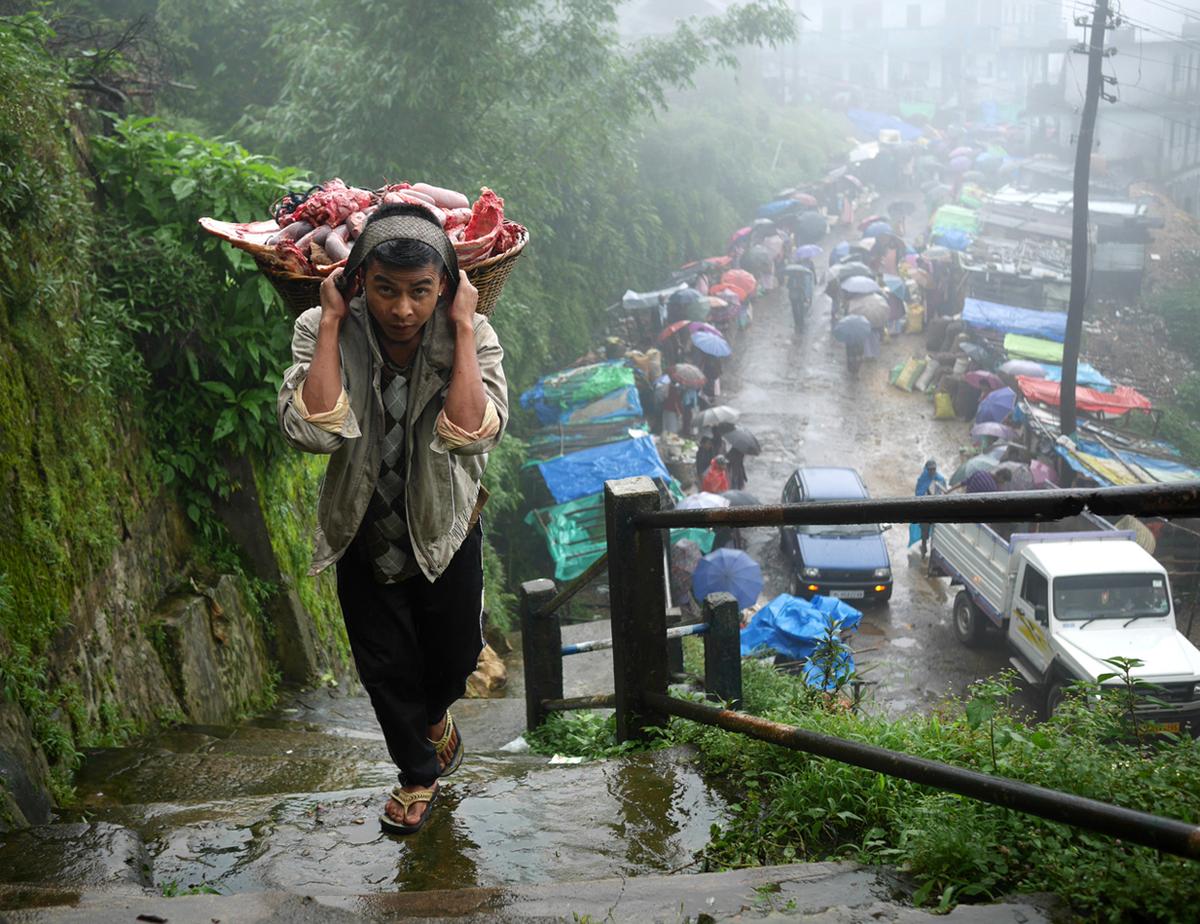 Winchester Lyngkhoi đang mang thịt tươi gian hàng của anh vào ngày họp chợ. Khi hỏi có gặp vất vả vì sống ở một nơi nhiều mưa như này, chàng trai 26 tuổi đáp: "Chúng tôi không nghĩ về điều ấy khi hăng say lao động".